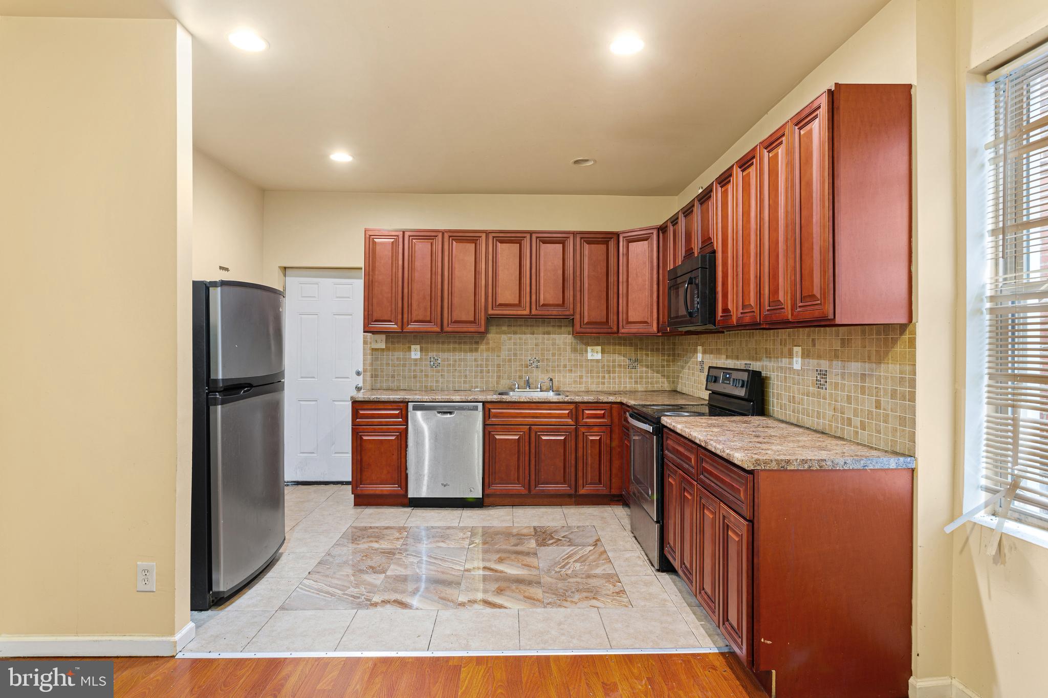 a kitchen with stainless steel appliances granite countertop a refrigerator sink and cabinets
