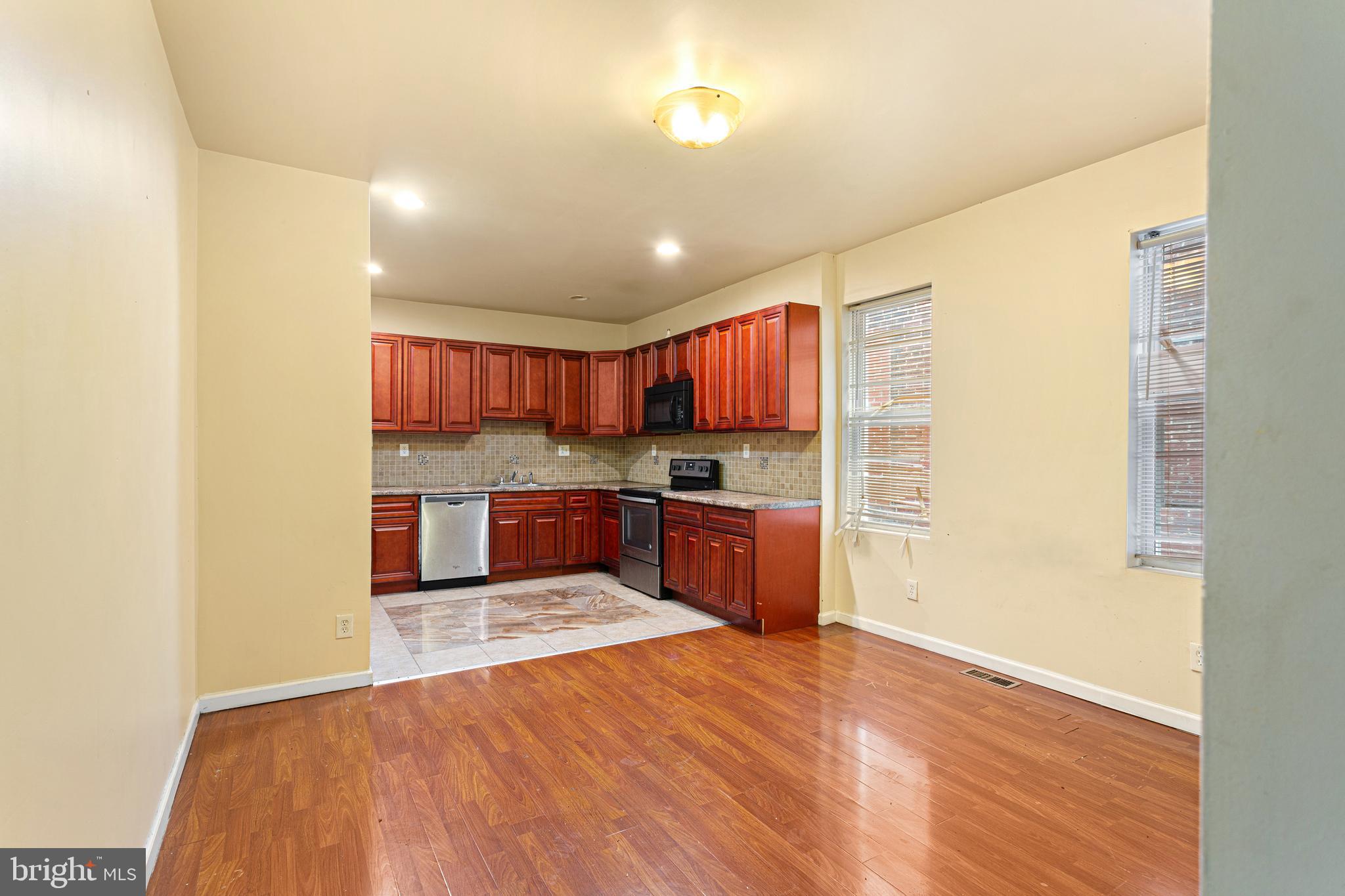 5446 Walnut Street, Unit 1 Philadelphia, PA 19139 - Photo 2 of 15 a open kitchen with kitchen island a sink dishwasher stove with wooden floors