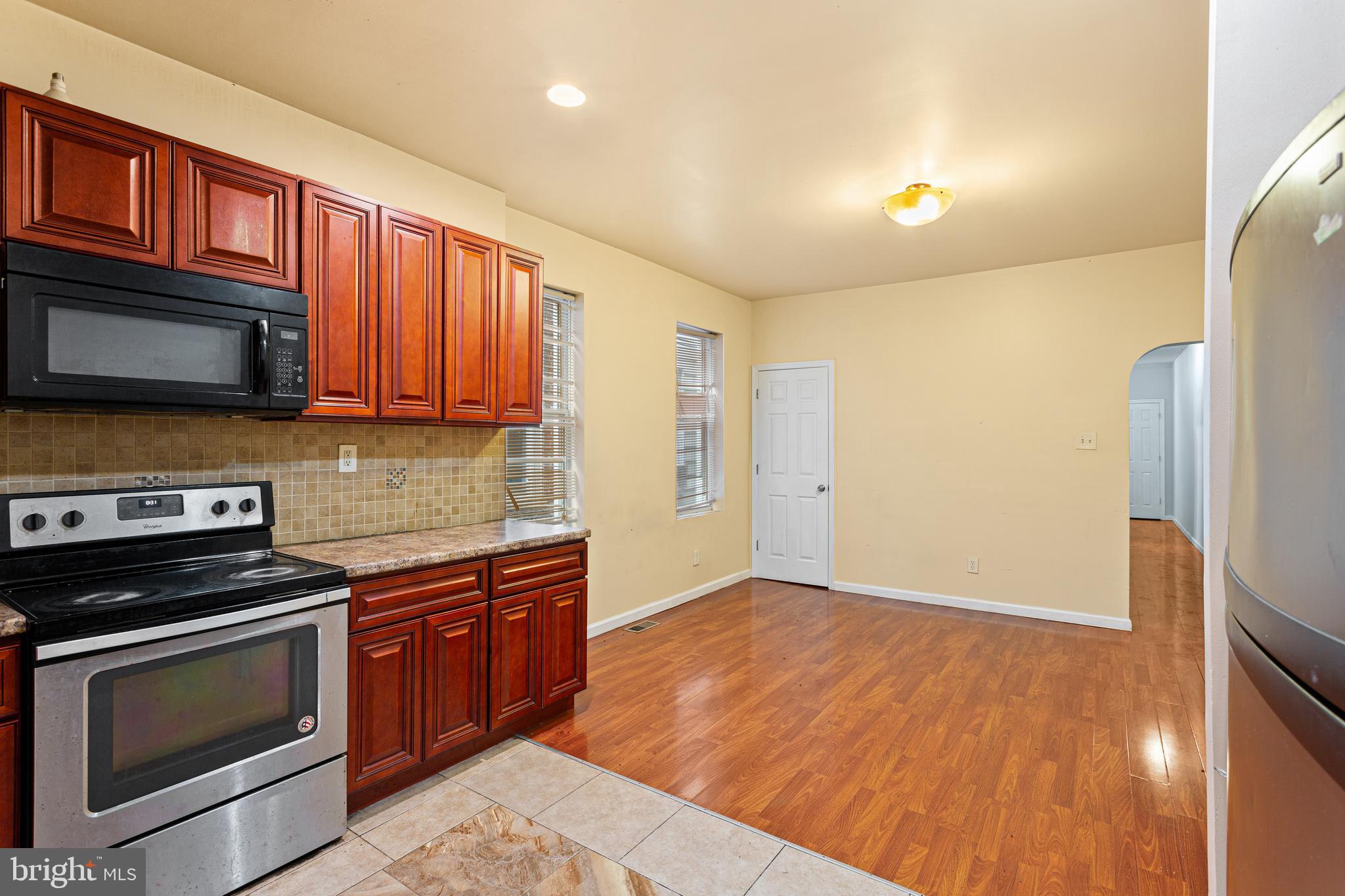 5446 Walnut Street, Unit 1 Philadelphia, PA 19139 - Photo 3 of 15 a kitchen with granite countertop wooden cabinets stainless steel appliances and a counter space