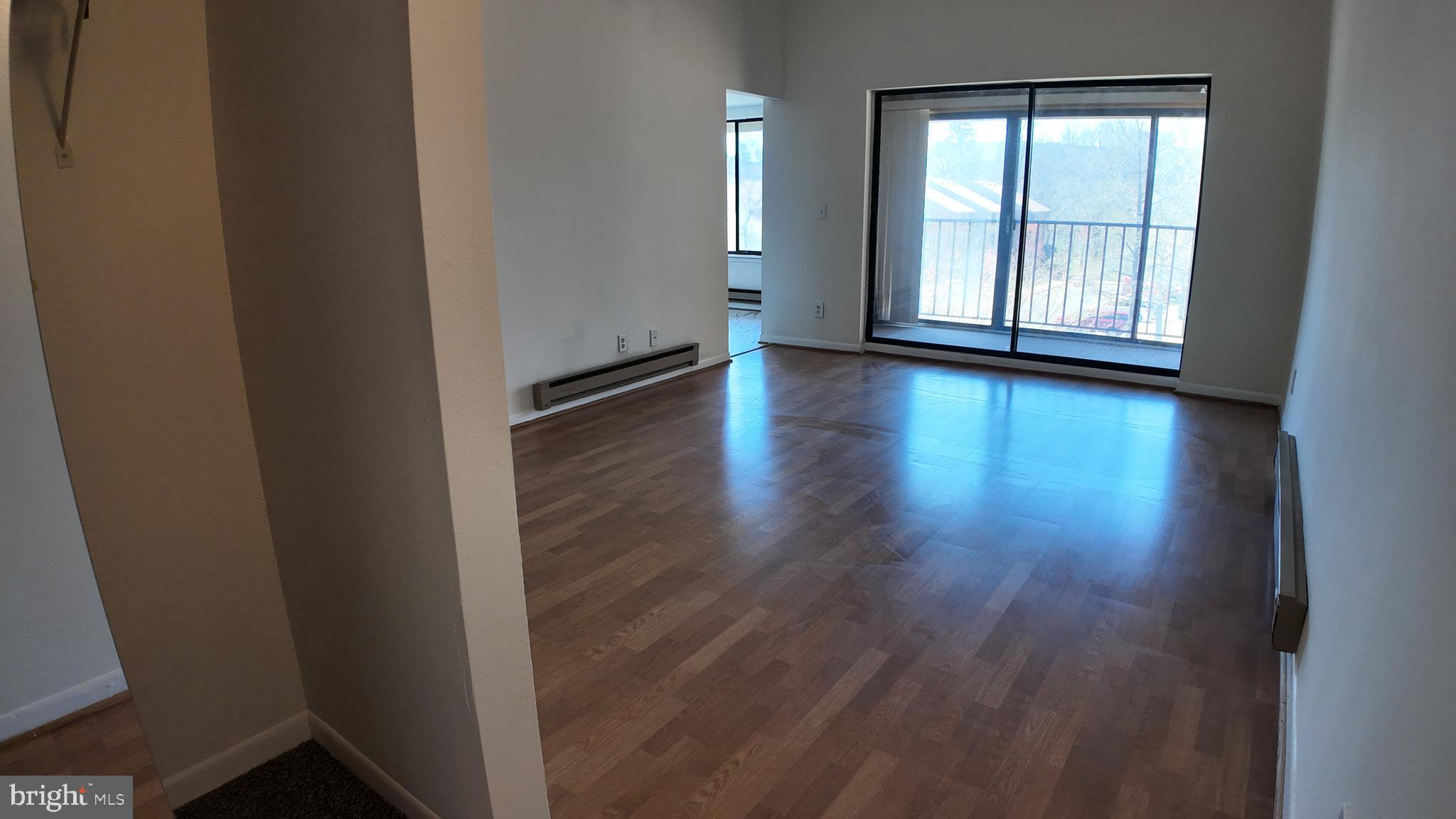 15311 Beaverbrook Court, Unit 903B Silver Spring, MD 20906 - Photo 9 of 36 a view of an empty room with wooden floor and a window