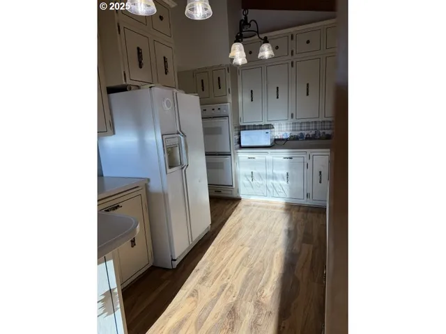 a kitchen with granite countertop a refrigerator and a sink