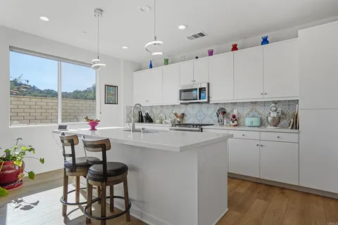 a kitchen with kitchen island granite countertop a sink cabinets and stainless steel appliances