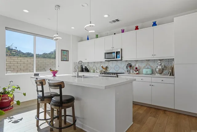 a kitchen with kitchen island granite countertop a sink cabinets and stainless steel appliances