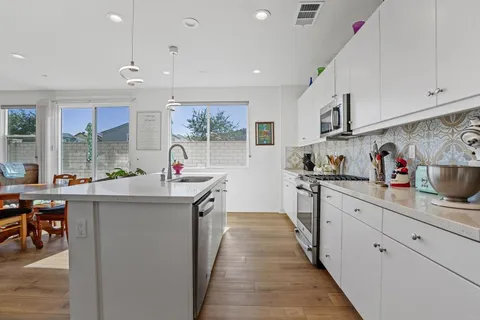 a kitchen with stainless steel appliances granite countertop a sink and cabinets