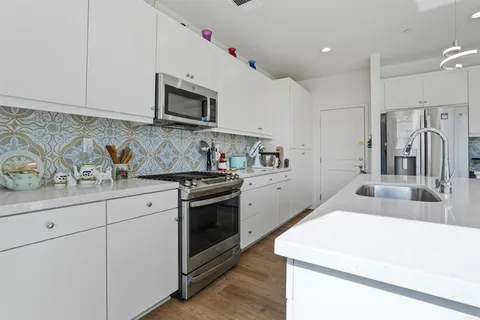 a kitchen with granite countertop a sink stove and refrigerator