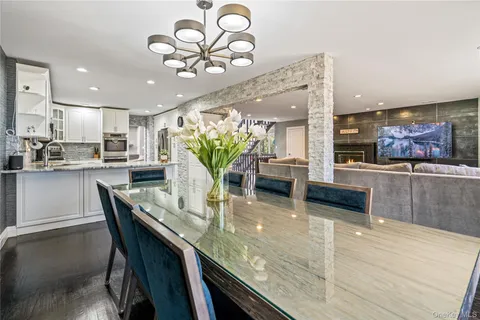 a kitchen with stainless steel appliances granite countertop a stove top oven a sink with dining table and chairs