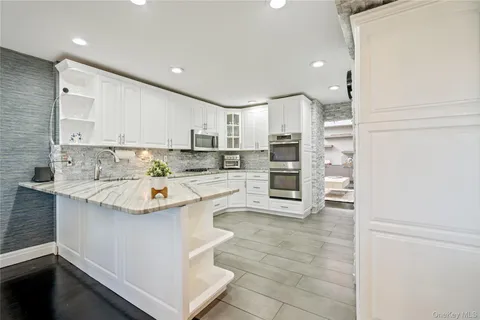 a kitchen with stainless steel appliances kitchen island granite countertop a sink and cabinets