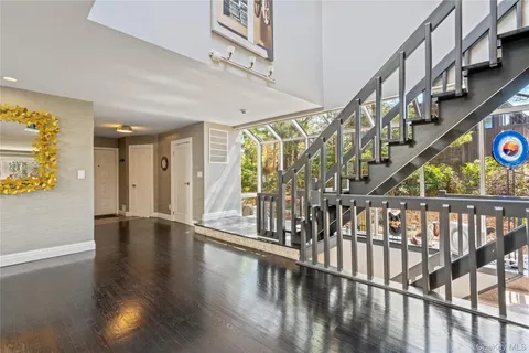 a view of an entryway wooden floor and an entrance door