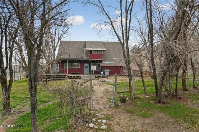 an aerial view of a house with a yard and large trees