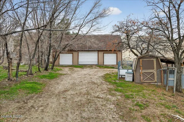 front view of a house with a tiny house and a large tree