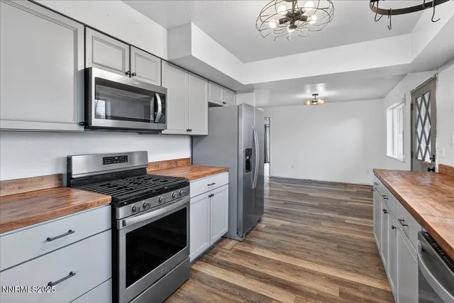 a kitchen with stainless steel appliances granite countertop a stove a refrigerator and a microwave