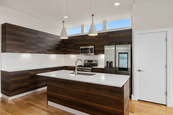 a kitchen with kitchen island a counter space a sink and a stove