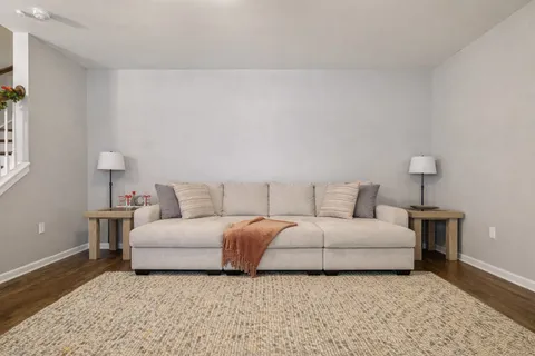 a living room with a white couch and a lamp on table