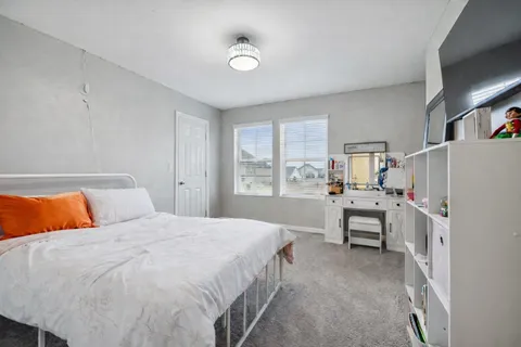 a bedroom with a bed and a refrigerator