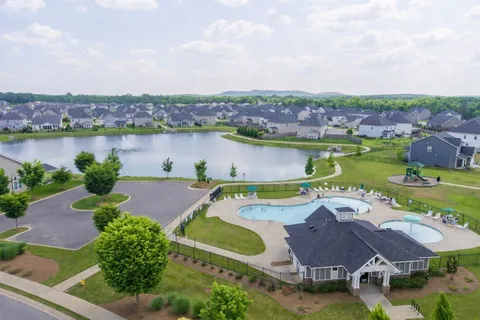 an aerial view of a house with outdoor space and lake view in back