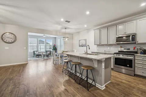 a kitchen with granite countertop a stove top oven a sink a counter space and cabinets