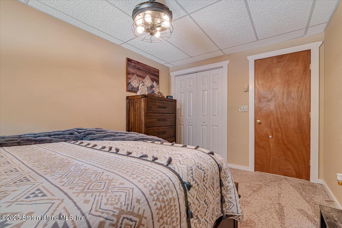 134 Split Rock Road Dingmans Ferry, PA 18328 - Photo 40 of 84 a bedroom with a bed and a chandelier