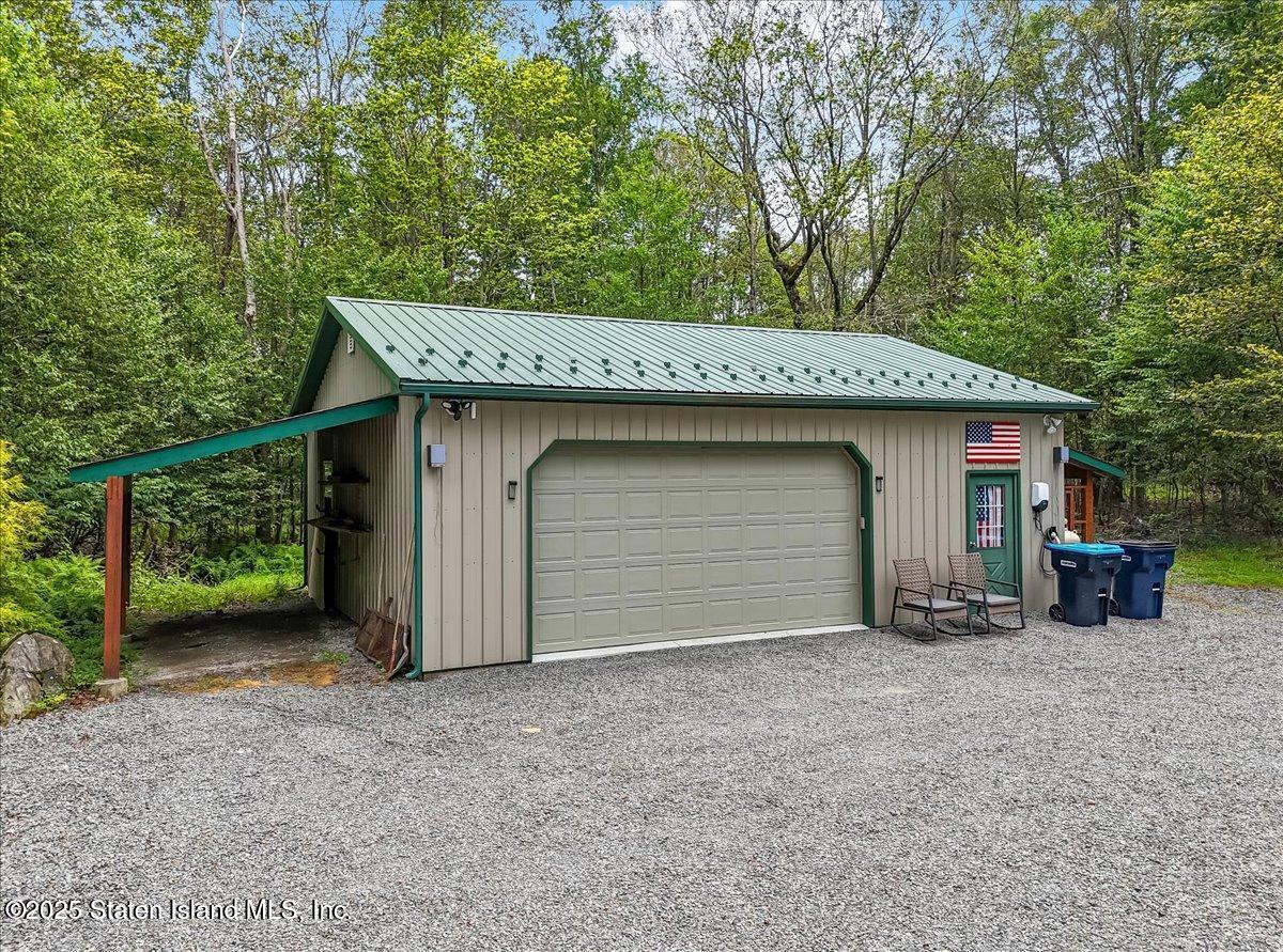 134 Split Rock Road Dingmans Ferry, PA 18328 - Photo 66 of 84 a front view of a house with a garden and garage