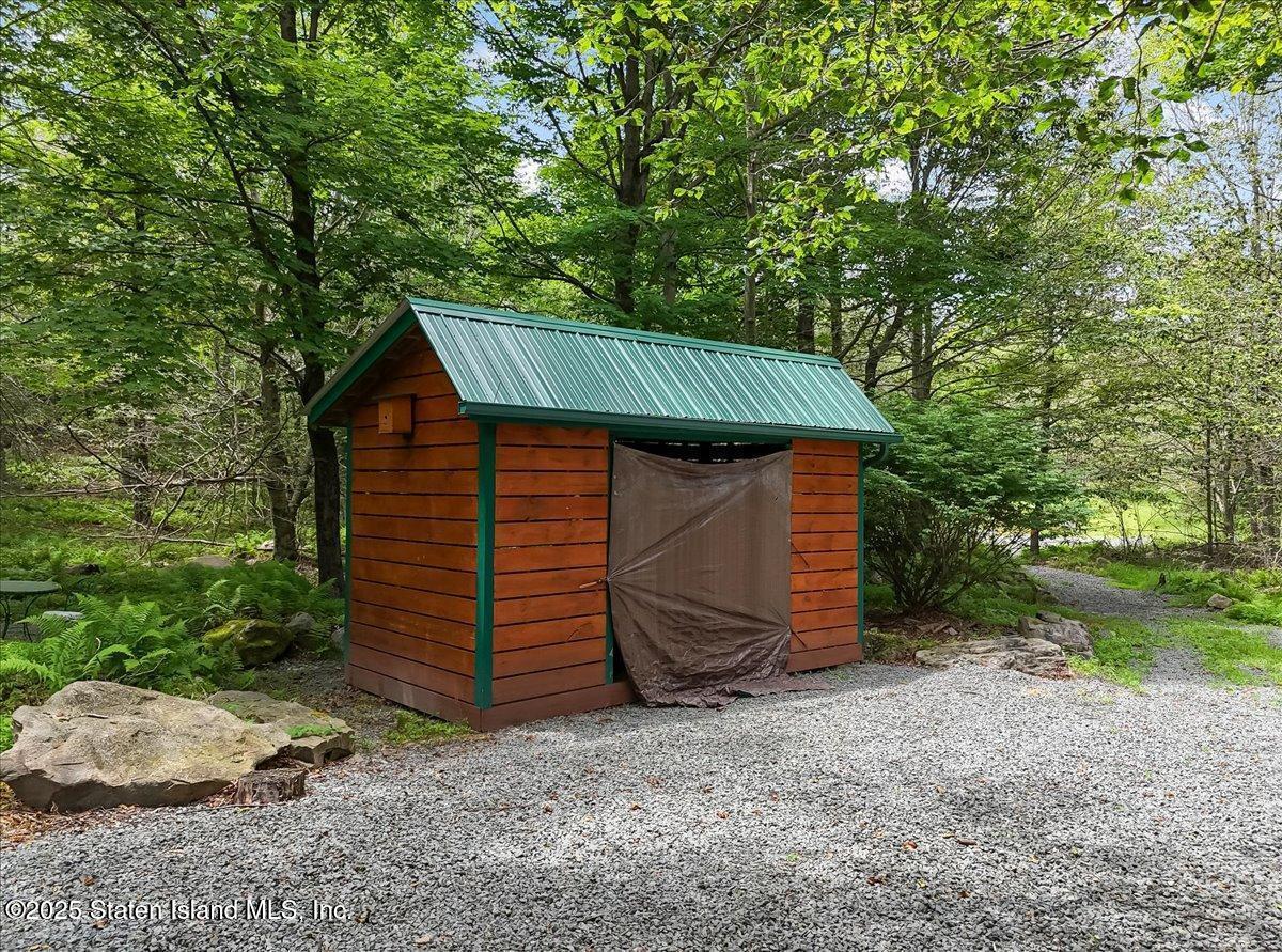 134 Split Rock Road Dingmans Ferry, PA 18328 - Photo 68 of 84 a view of a small house with a small yard and large tree