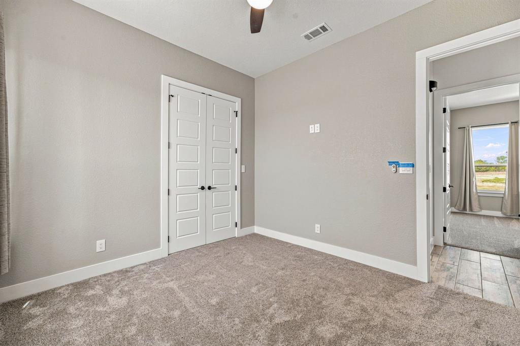 8140 Lavender Road Springtown, TX 76082 - Photo 23 of 40 Carpeted room featuring a ceiling fan, white trim, and a double door entry