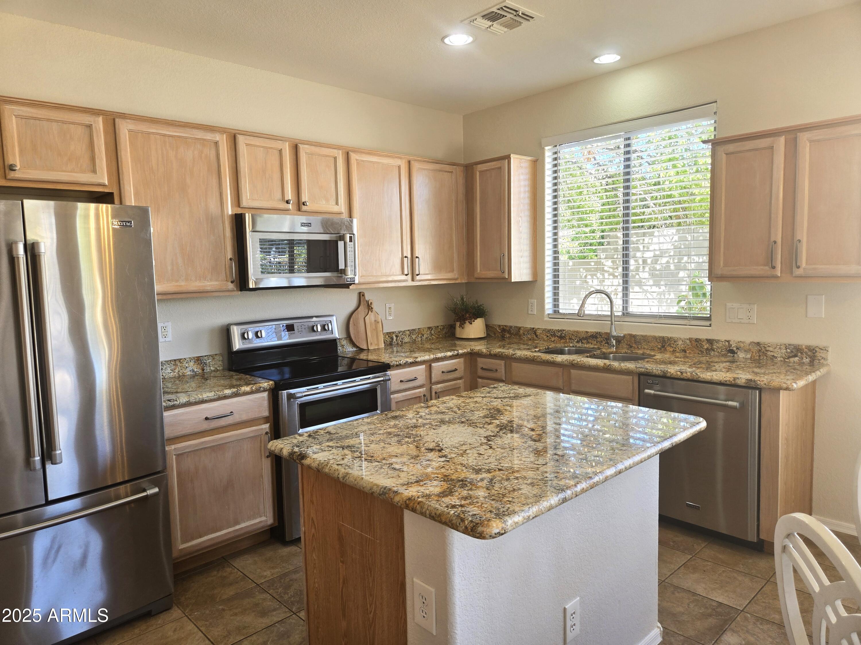 1187 South Hazel Street Gilbert, AZ 85296 - Photo 13 of 50 a kitchen with granite countertop a sink stove and refrigerator