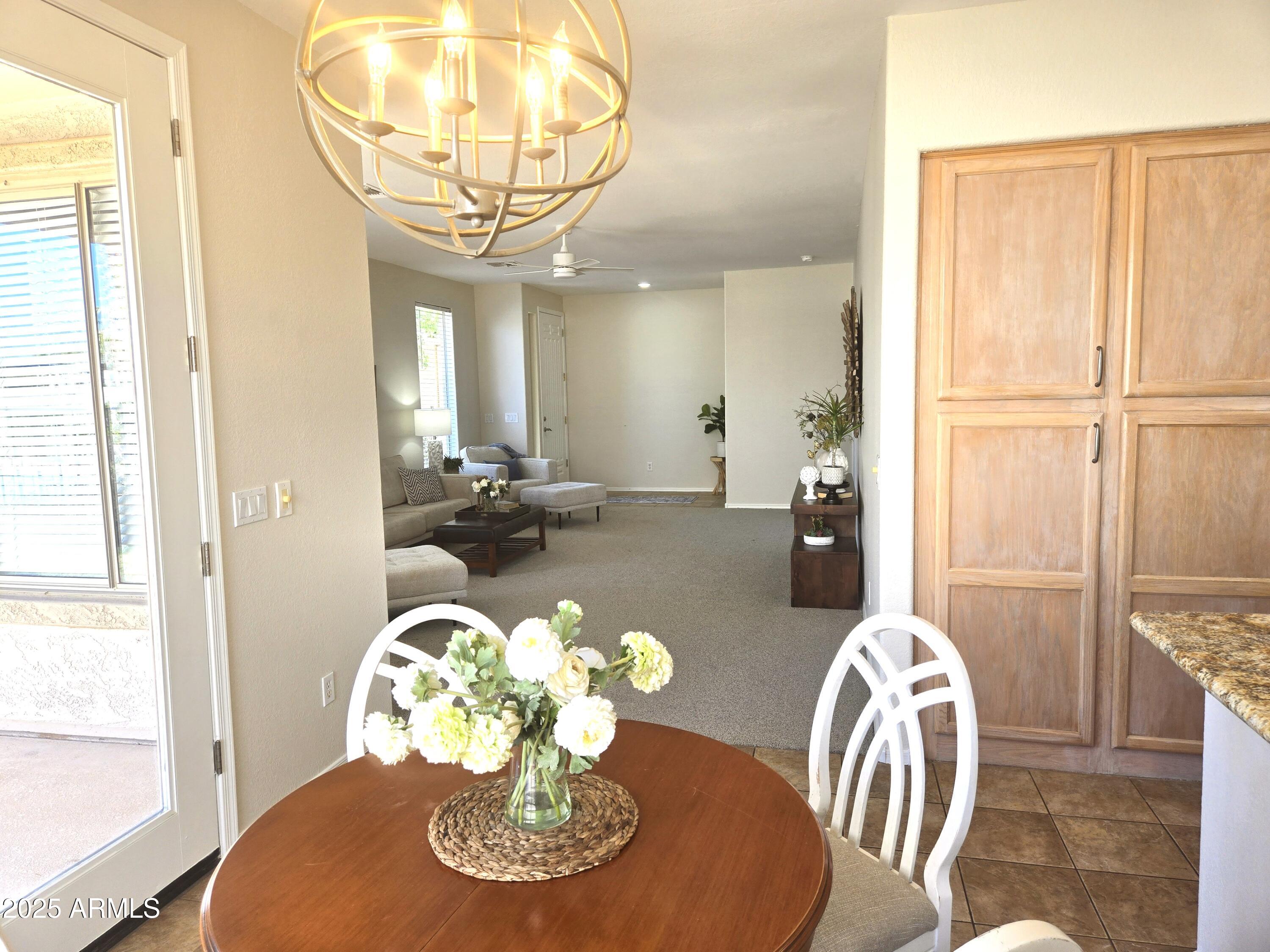 1187 South Hazel Street Gilbert, AZ 85296 - Photo 15 of 50 a dining room with furniture a large window and wooden floor