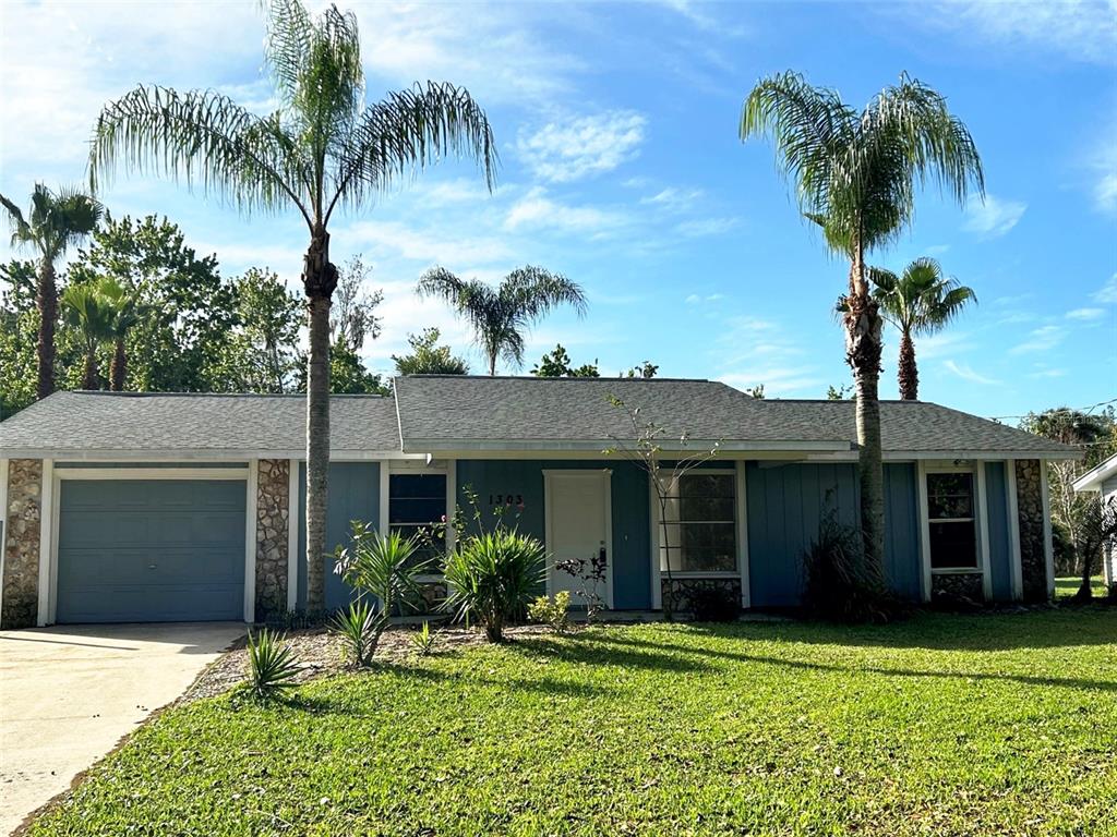 1303 36th Street Edgewater, FL 32141 - Photo 1 of 1 a front view of a house with a yard and garage