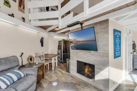 a living room with furniture a flat screen tv and a fireplace