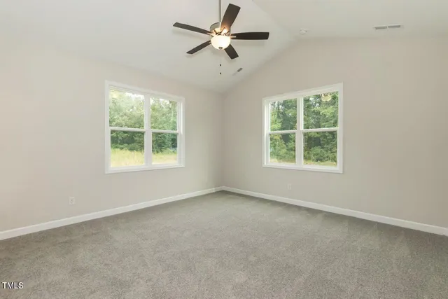 an empty room with a window and a fan