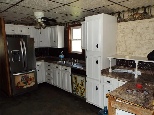 a kitchen with stainless steel appliances granite countertop a sink a stove and a refrigerator