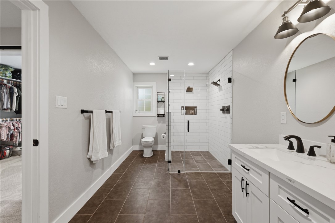 515 Crescent Drive Bryan, TX 77801 - Photo 22 of 43 Spacious bathroom featuring a glass-enclosed shower with subway tile, dual showerheads, and a built-in niche