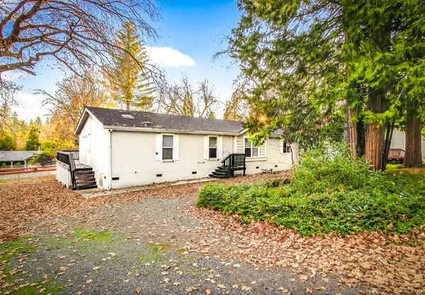 a white house that has a tree in front of it