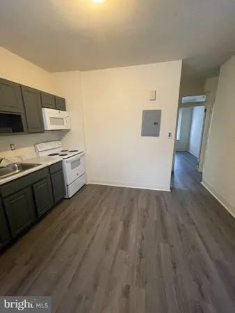 a view of a kitchen with wooden floor and electronic appliances