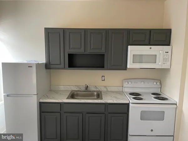 a kitchen with stainless steel appliances a stove a microwave and white cabinets