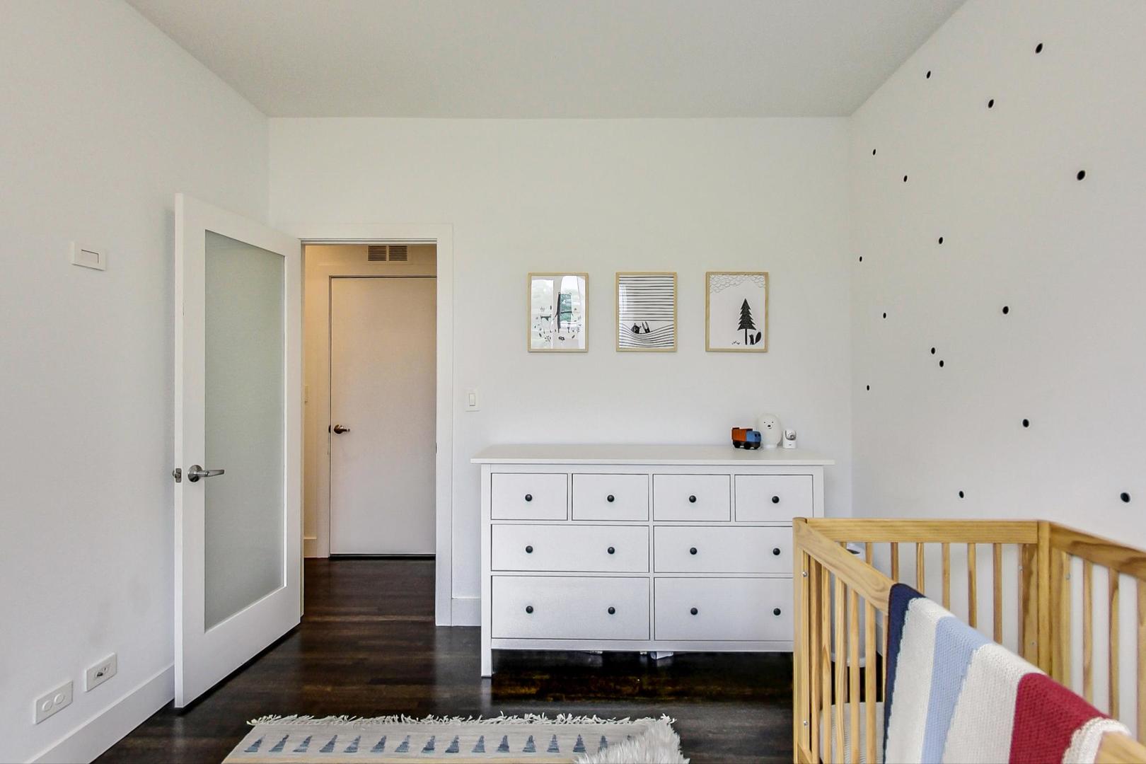 1944 West Thomas Street, Unit 2 Chicago, IL 60622 - Photo 20 of 28 a view of a bedroom with baby crib and dresser