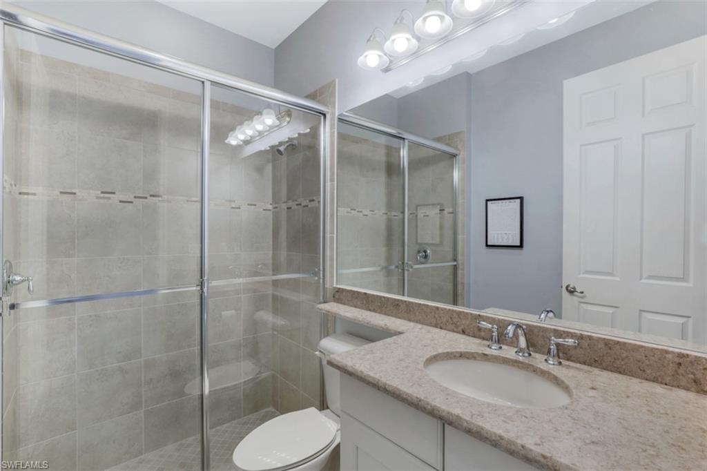 3082 Hudson Terrace Naples, FL 34119 - Photo 18 of 35 a bathroom with a granite countertop sink toilet and shower