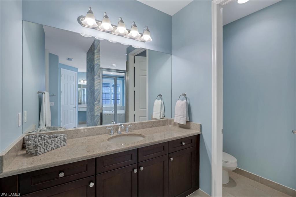 3082 Hudson Terrace Naples, FL 34119 - Photo 25 of 35 a bathroom with a granite countertop sink a toilet and a mirror