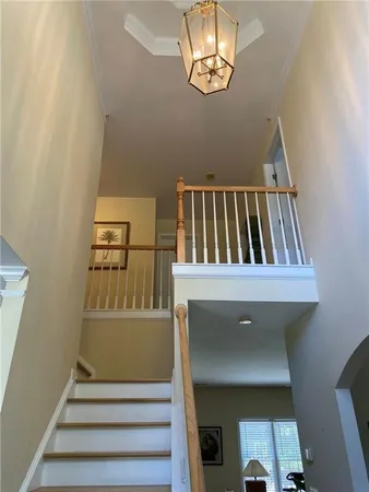 a view of staircase with railing and white walls