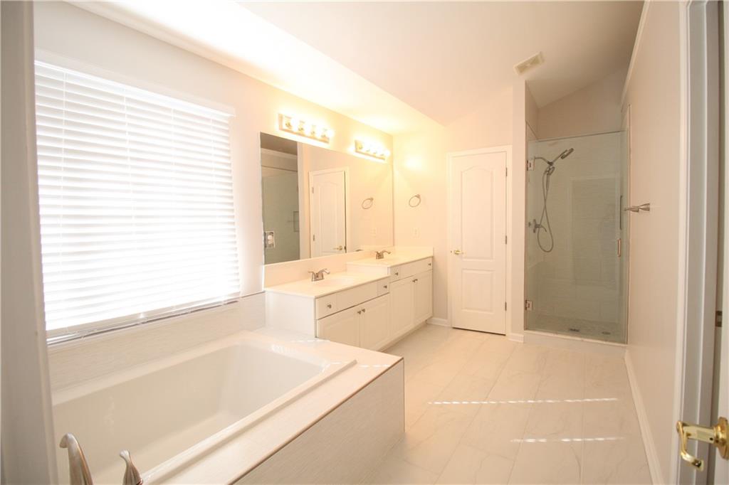 3343 Mill Grove Terrace Dacula, GA 30019 - Photo 15 of 28 a large bathroom with a tub sink shower and mirror