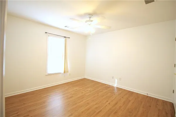 an empty room with wooden floor and a window