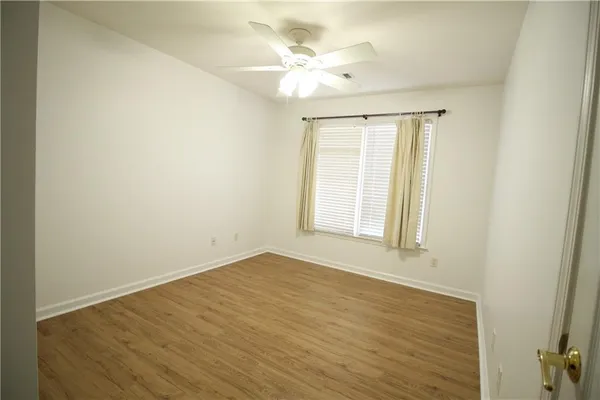an empty room with a window and a ceiling fan