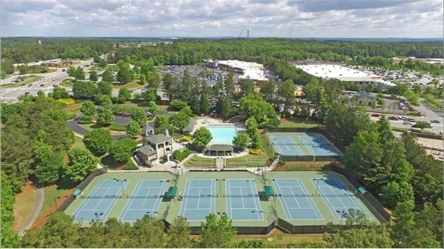 an aerial view of residential houses with outdoor space and trees