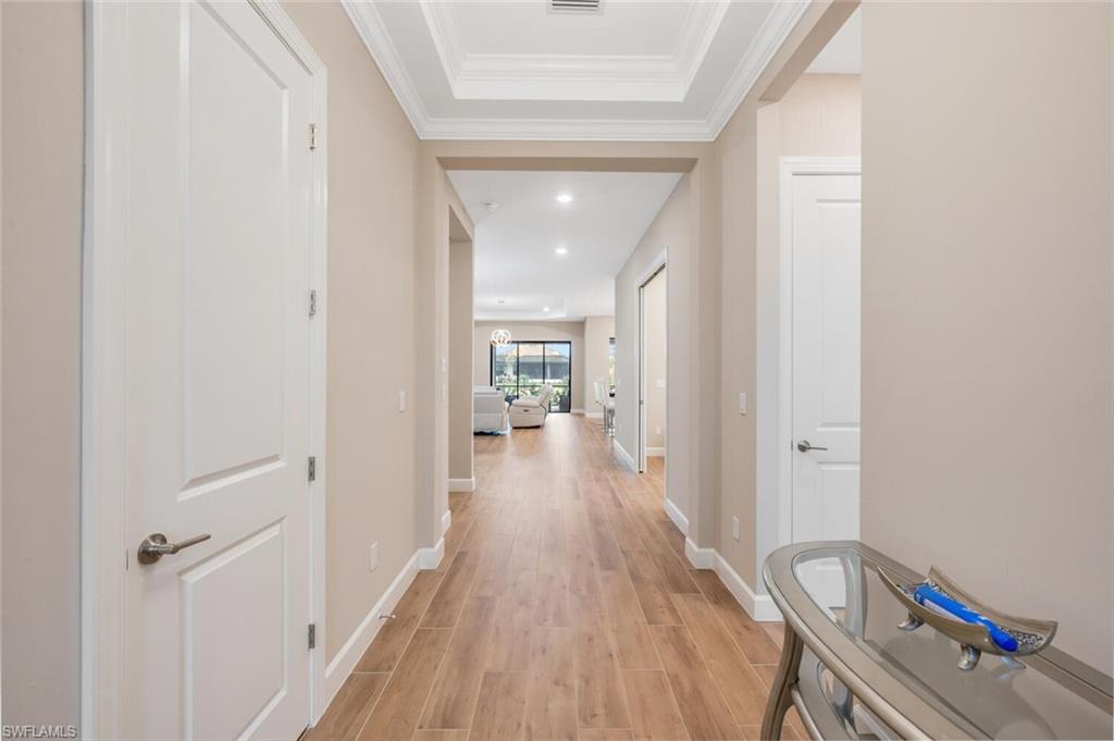 8448 Rosa Court Naples, FL 34114 - Photo 2 of 24 Long hallway featuring wood-finish flooring, recessed lighting, white baseboards, and neutral wall tones