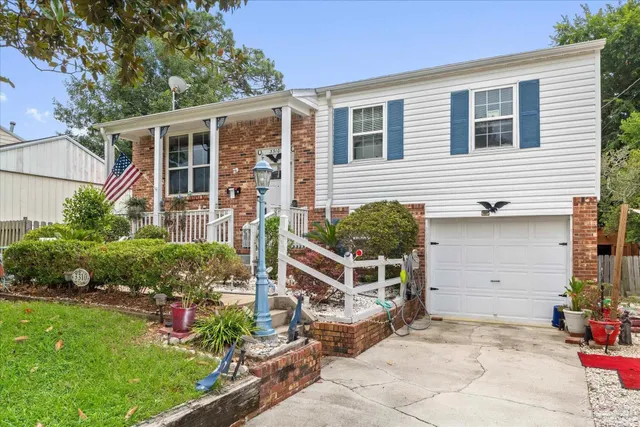 a view of house with a yard and potted plants