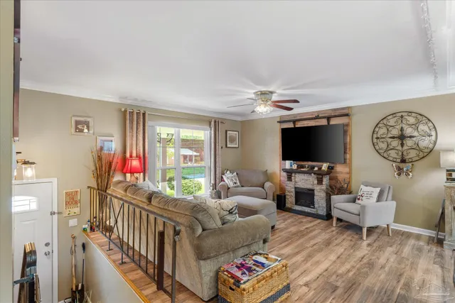 a living room with furniture a flat screen tv and a large window