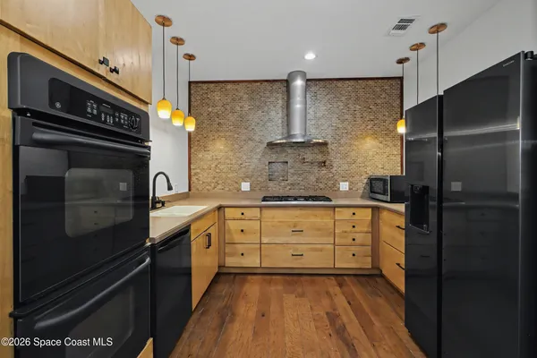 a kitchen with stainless steel appliances a refrigerator and a stove top oven
