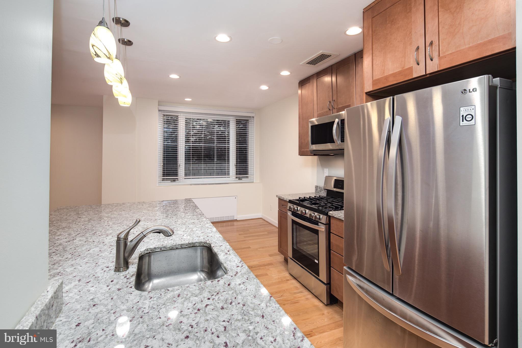 2475 Virginia Avenue Northwest, Unit 103 Washington, DC 20037 - Photo 6 of 16 a kitchen with granite countertop a refrigerator stove and sink