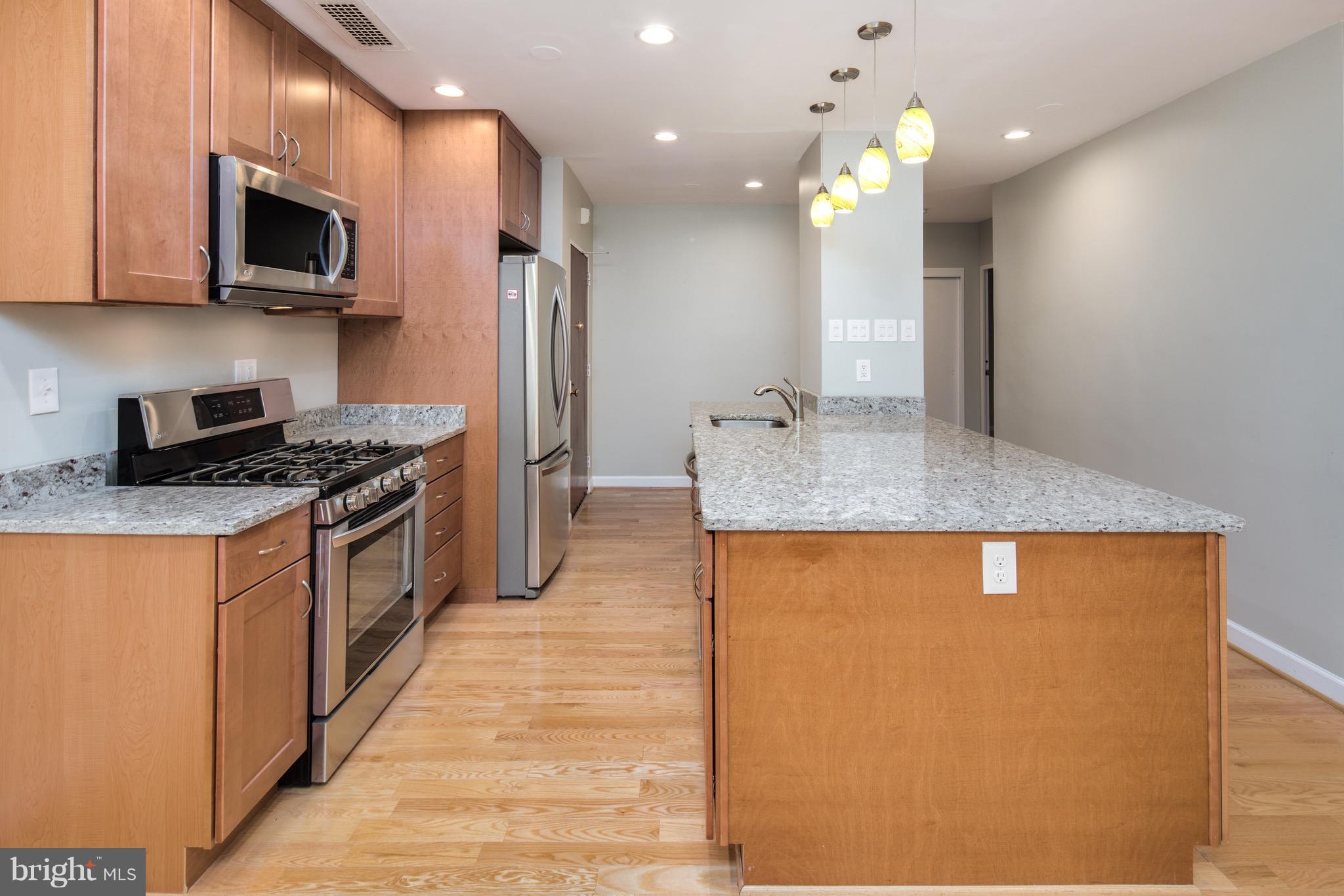 2475 Virginia Avenue Northwest, Unit 103 Washington, DC 20037 - Photo 7 of 16 a kitchen with stainless steel appliances granite countertop a sink a stove and a refrigerator