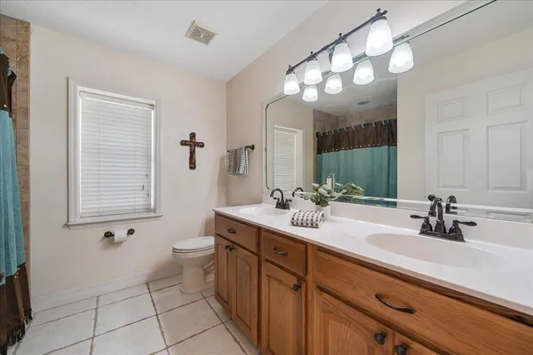 a bathroom with a double vanity sink a toilet and a mirror