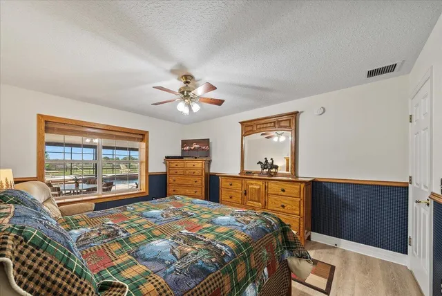a bedroom with a bed and a dresser next to a window